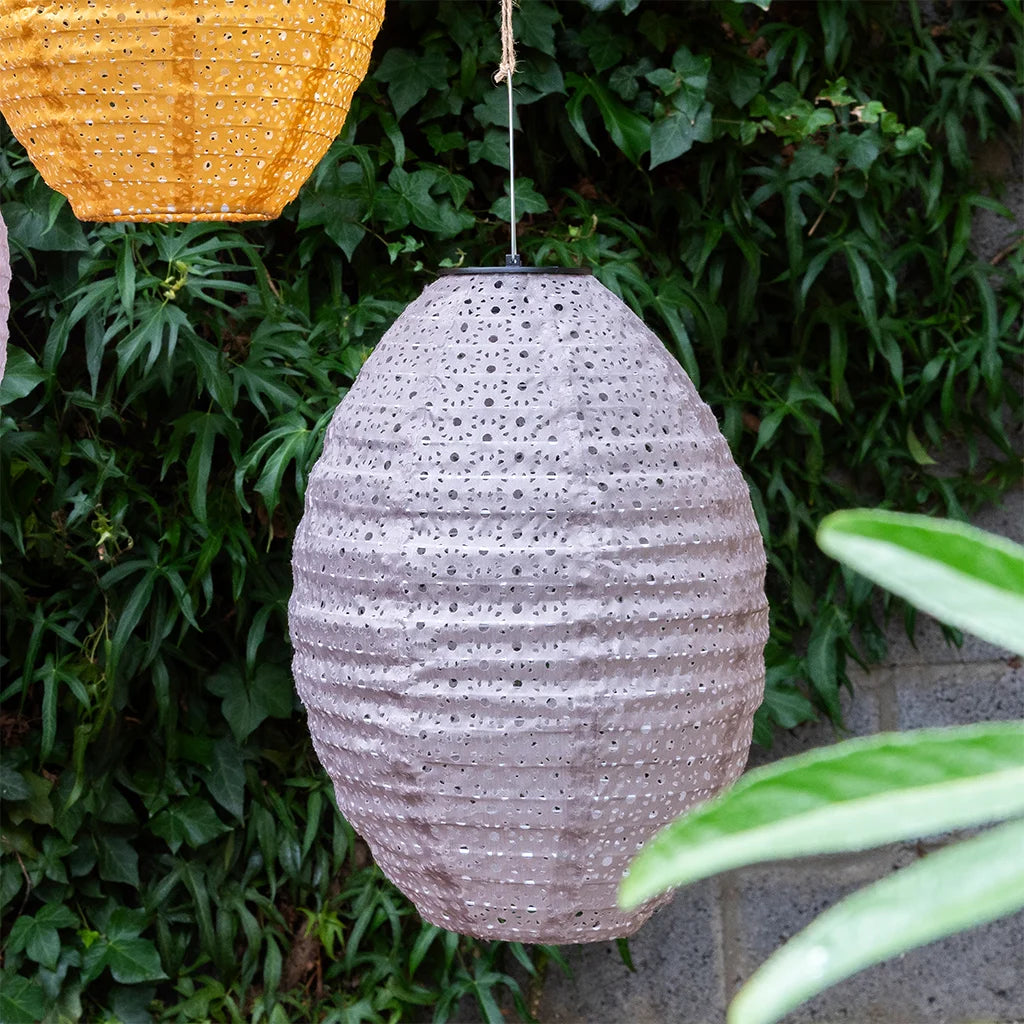 Textured hanging lamp against a green leafy background