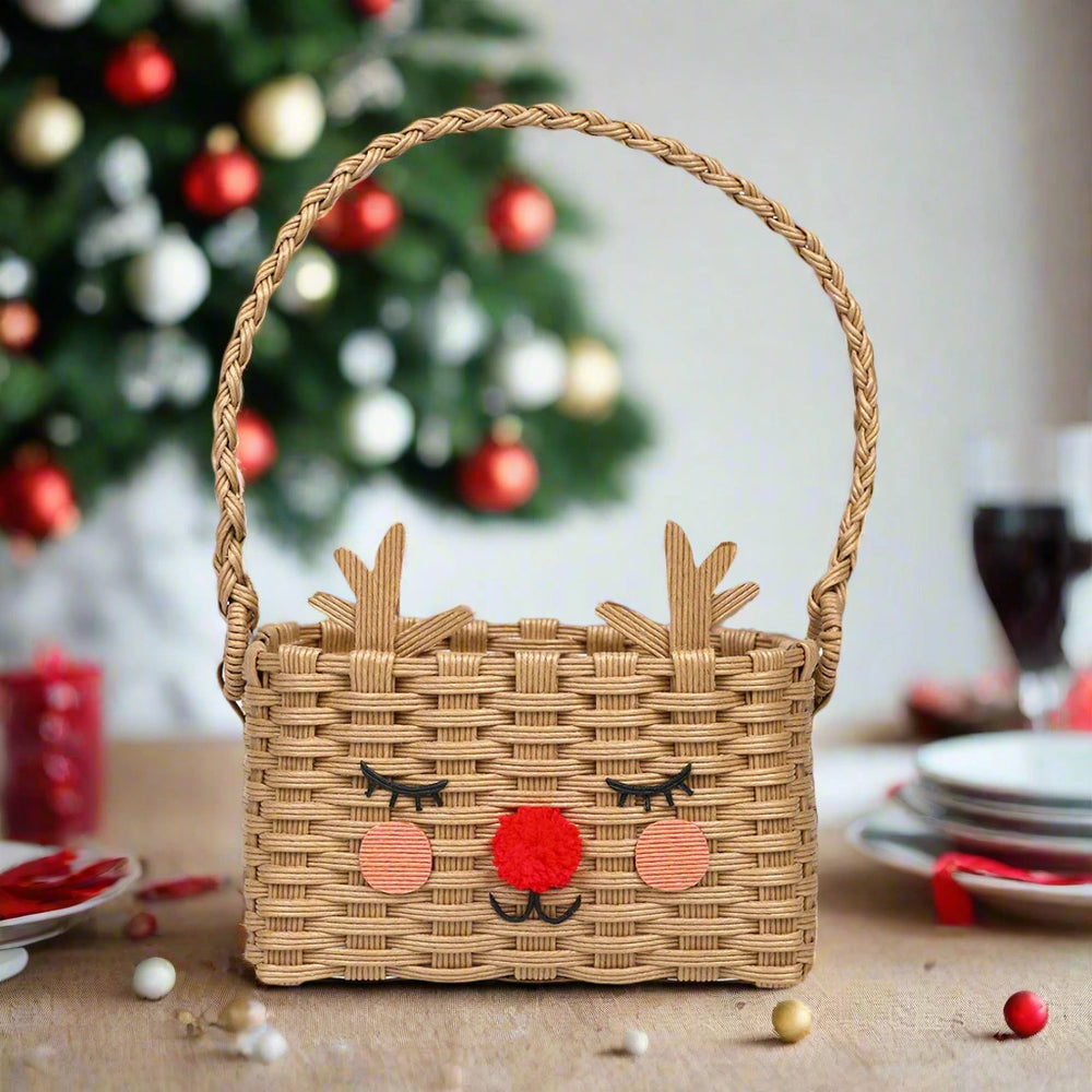 Woven basket with reindeer face design in front of a decorated Christmas tree.