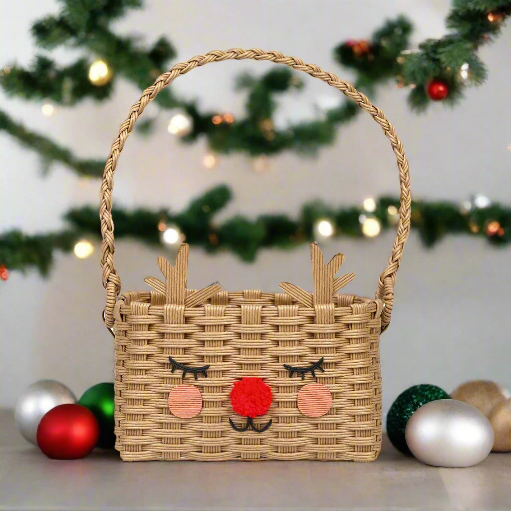 Woven basket with reindeer face design in front of a Christmas tree