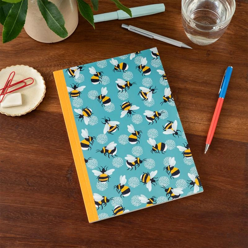 rex london A5 bumble print notebook on a wooden desk with colourful pen and stationery