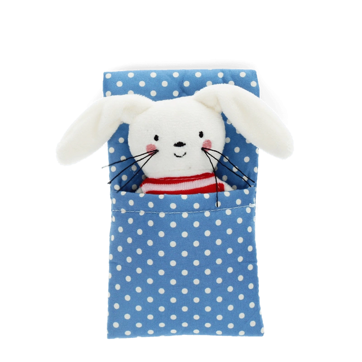 a white Bunny Soft Toy wearing a red stripe jumper in a a blue and white polka dot bed. 