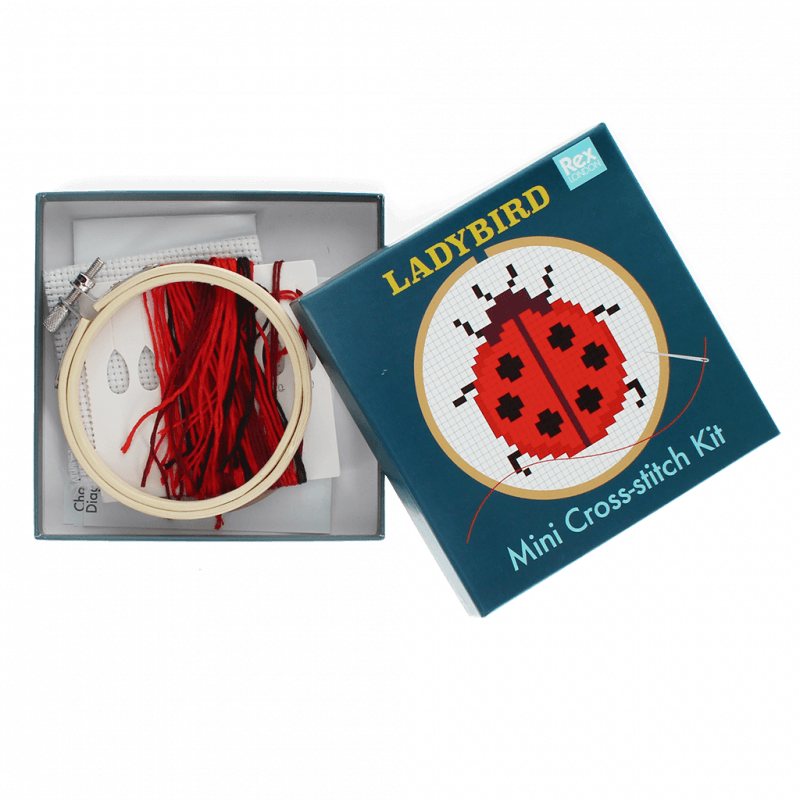 Rex London Ladybird cross stitch kit for children and beginners. The kit is in a dark blue box and the box is open showing the hoop and embroidery threads inside. 