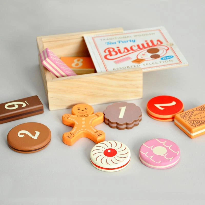 wooden biscuits play set featuring traditional biscuits - gingerbread man, bourbon, pink wafers and other classics. The biscuits are numbered on the back for a fun educational twist and come in a retro style wooden box. 