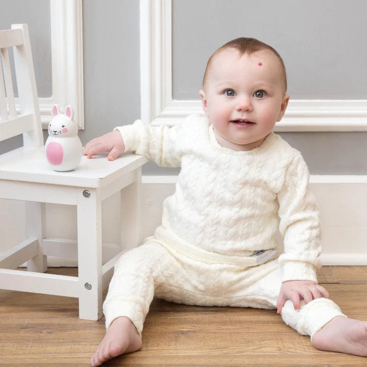 baby playing with a pink and white Rosa + Bo Pink Bo Bunny Chiming Shaker