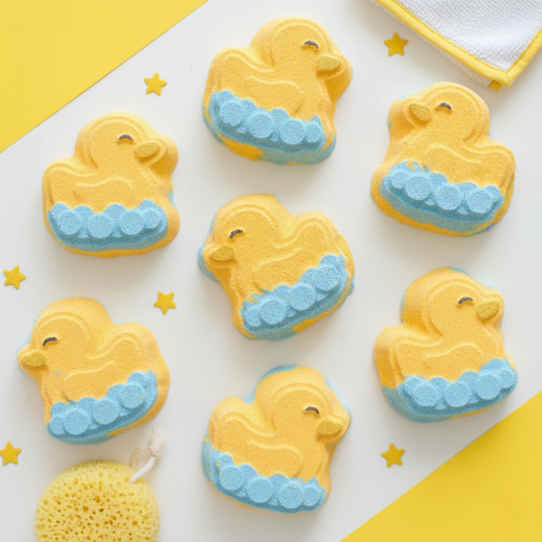 Yellow rubber ducky bath bombs with blue waves on a white background with yellow accents