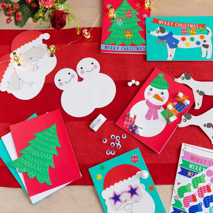 Collection of Christmas-themed greeting cards and craft materials on a red surface.