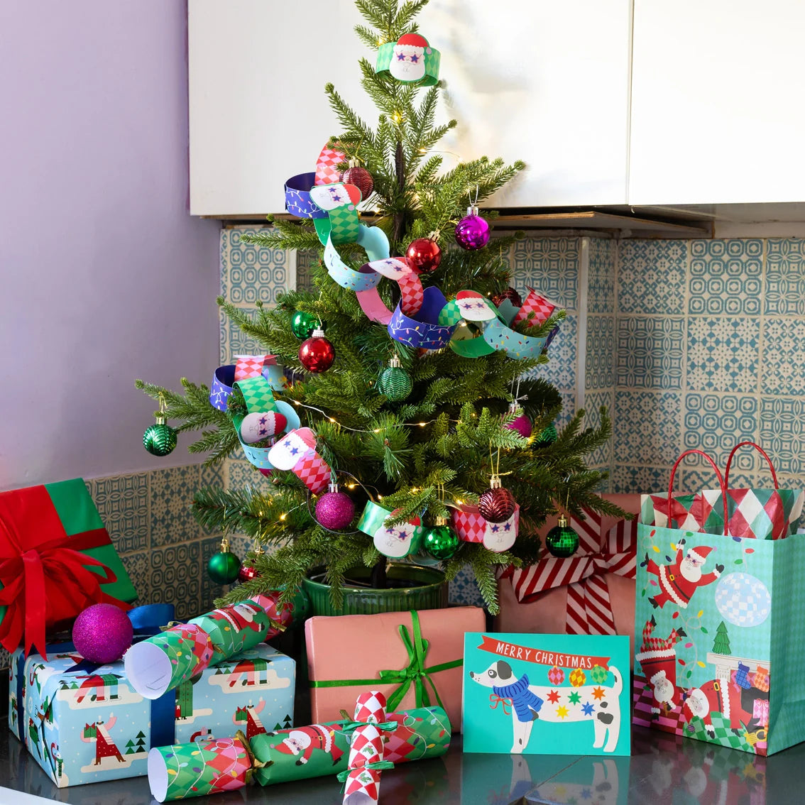 Decorated Christmas tree with ornaments and presents in a kitchen setting