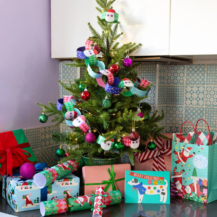 Decorated Christmas tree with ornaments and presents in a kitchen setting