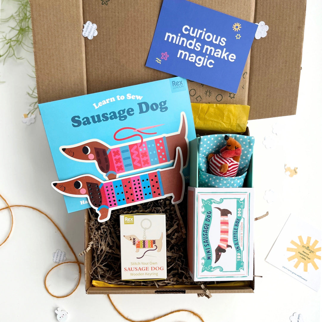 childrens craft gift box with 'Learn to Sew Sausage Dog', little sausage dog toy, sausage dog keying craft kit in a kraft gift box, featuring a 'curious minds make magic' card.