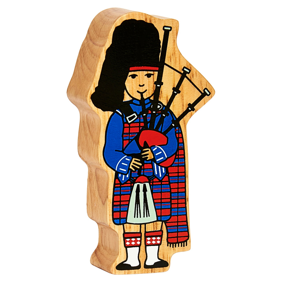 Wooden ornament with a Scottish bagpiper figure on a white background