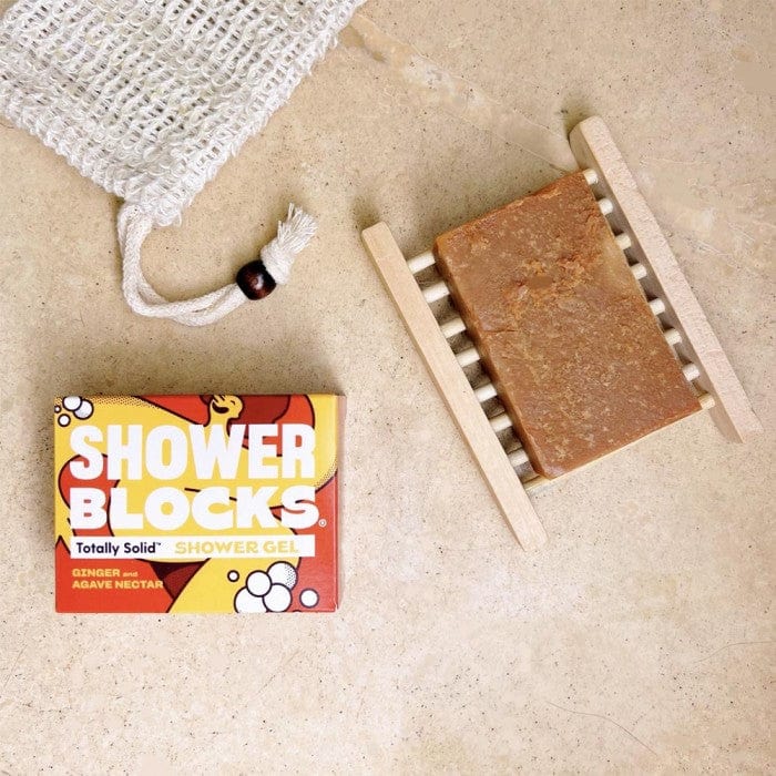 ginger and agave shower blocks bar on a soap dish next to packaging
