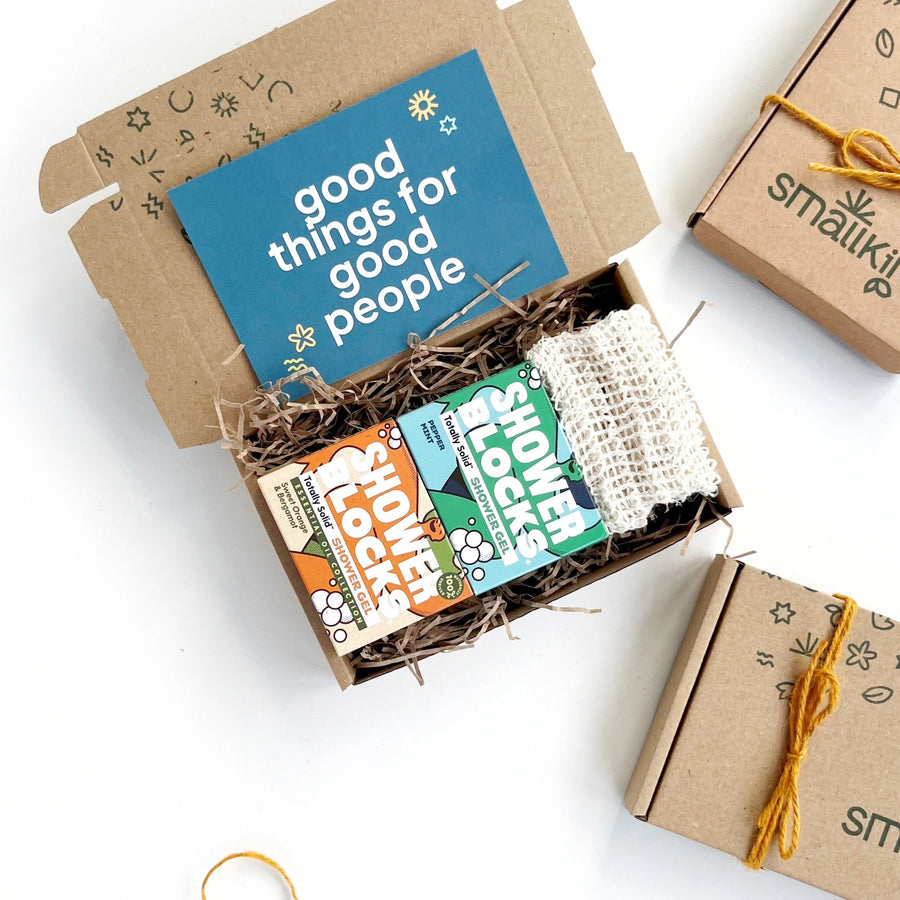 shower lovers gift boxes including two aromatherapy solid shower gel bars in colourful packaging and a natural sisal soap saver pouch. The products are inside a hand stamped kraft gift box with a card that reads 'good things for good people'. 