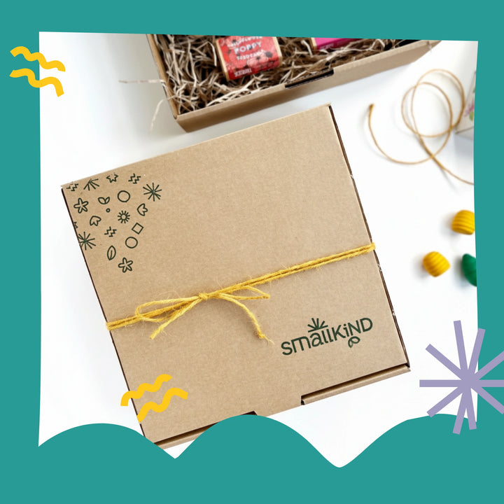 Kraft gift box with yellow twine featuring the 'Smallkind' brand, on a white background.