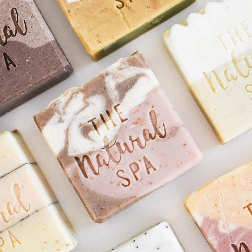 Various soap bars from The Natural Spa on a light background