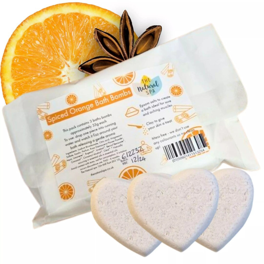 pack of three white heart shaped bath bombs with packaging, an orange slice and star anise on a light background