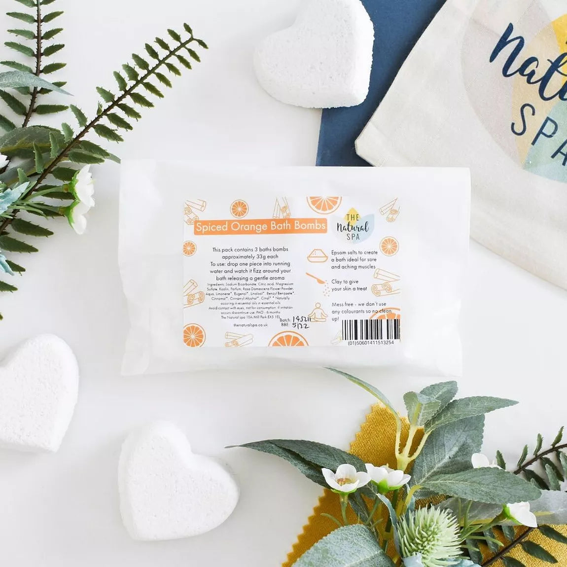 spiced orange bath bombs packaging with three white heart shaped bath bombs on a light background