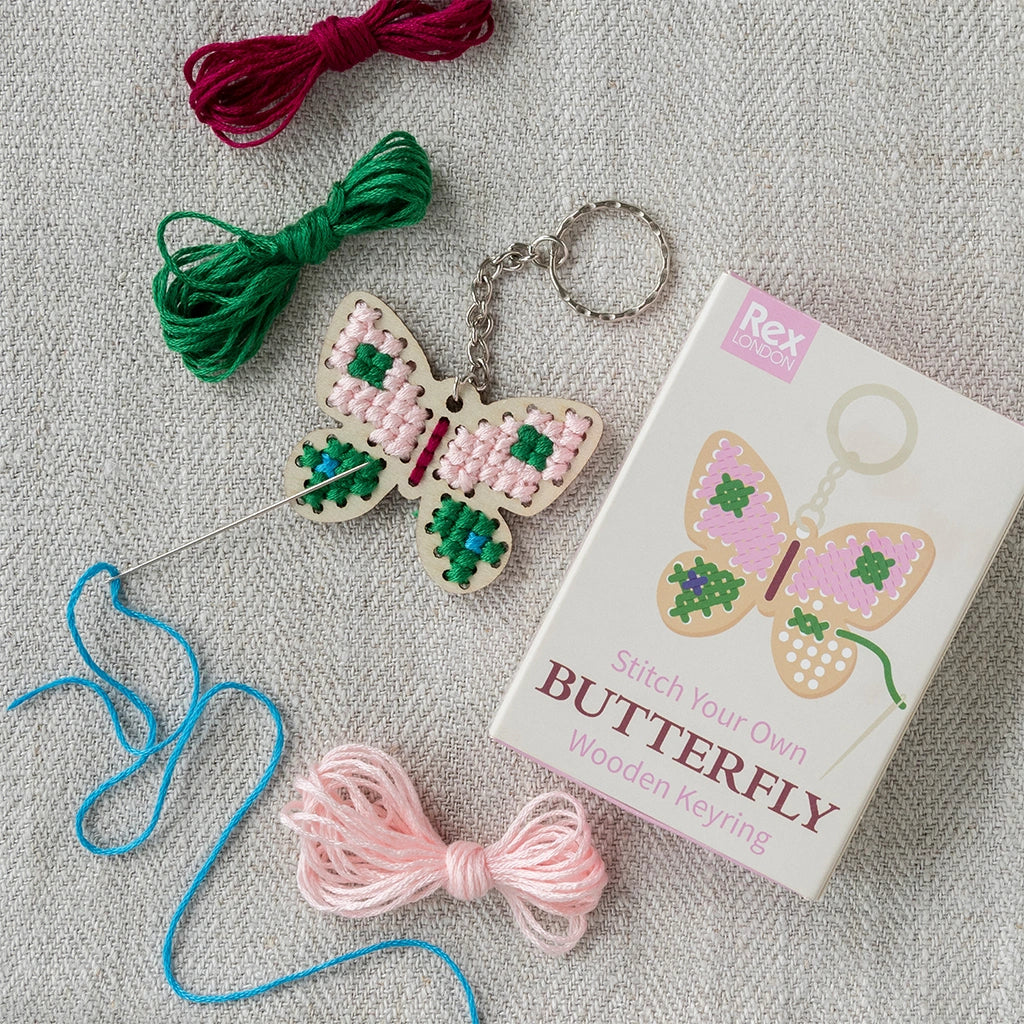 stitch your own butterfly keyring craft kit with threads and gift box on a linen table cloth. 
