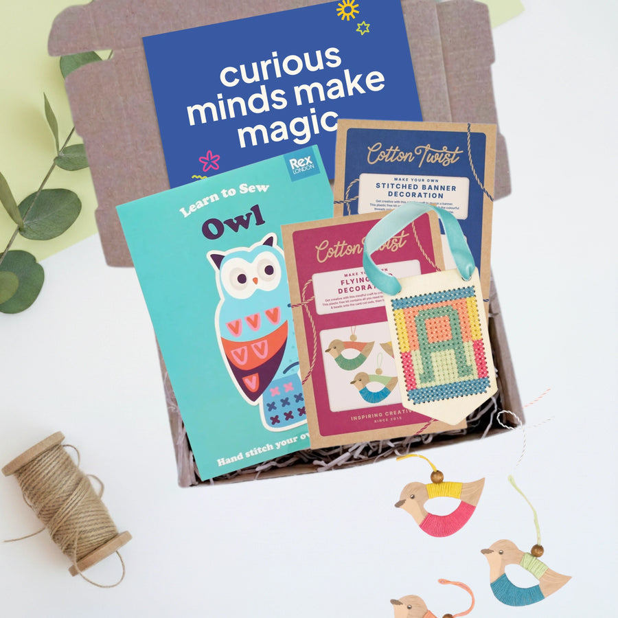 Educational craft gift box with three wooden craft kits and materials on a white background