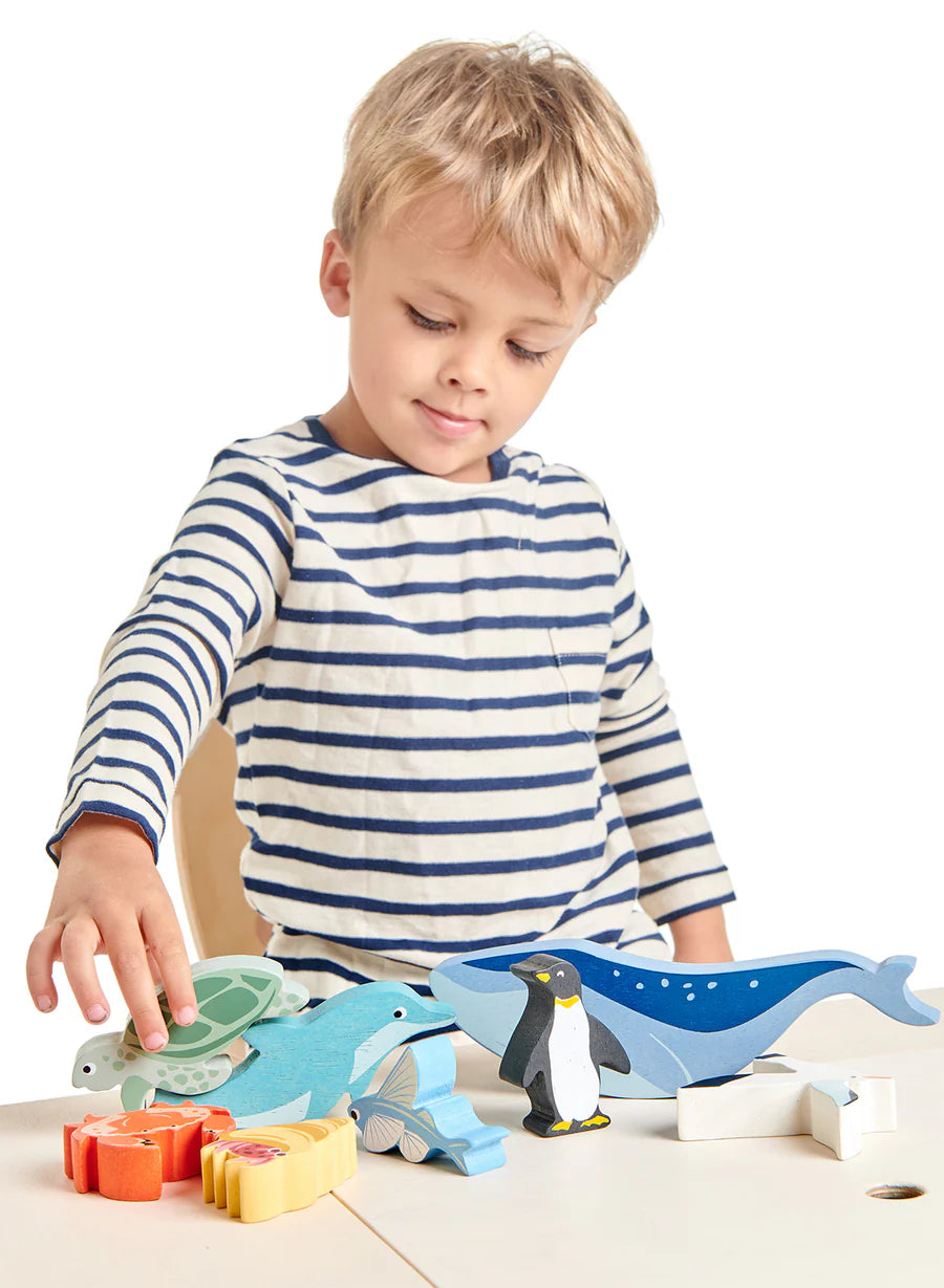 boy playing with wooden sea creatures from the Tender Leaf Coastal Animals Shelf Set 