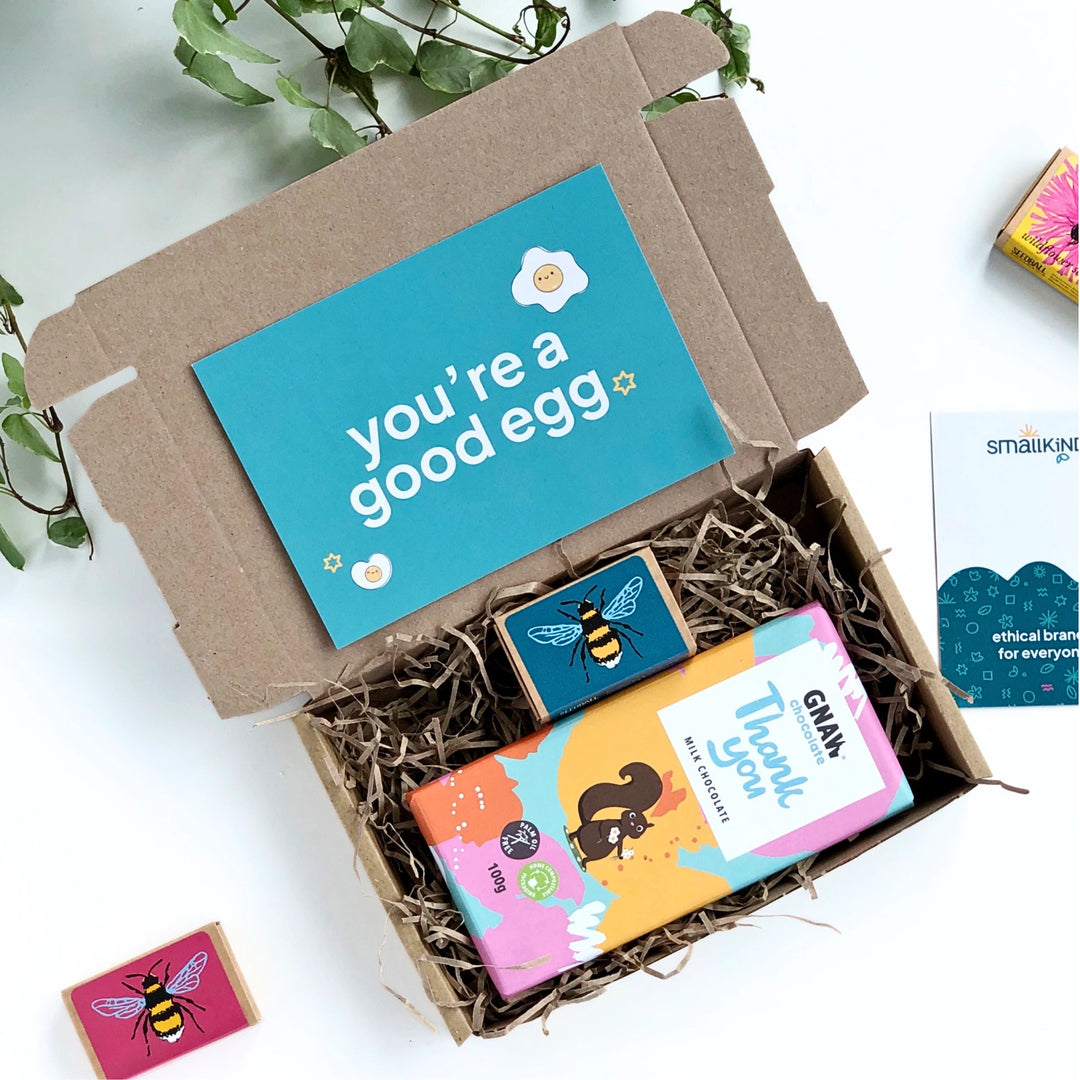 thank you chocolate bar in colourful packaging, teal match box with a yellow bee on the from and seedballs inside.  Both products are in a smallkind krfat gift box with a 'you're a good egg' card. 