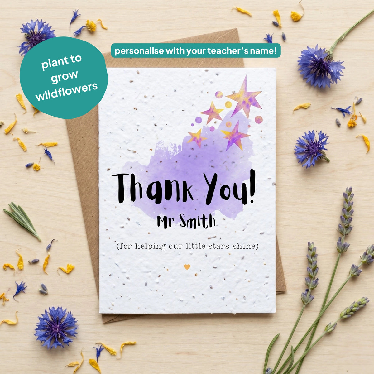 Seed paper card with 'Thank You!' message on a wooden surface with flowers.