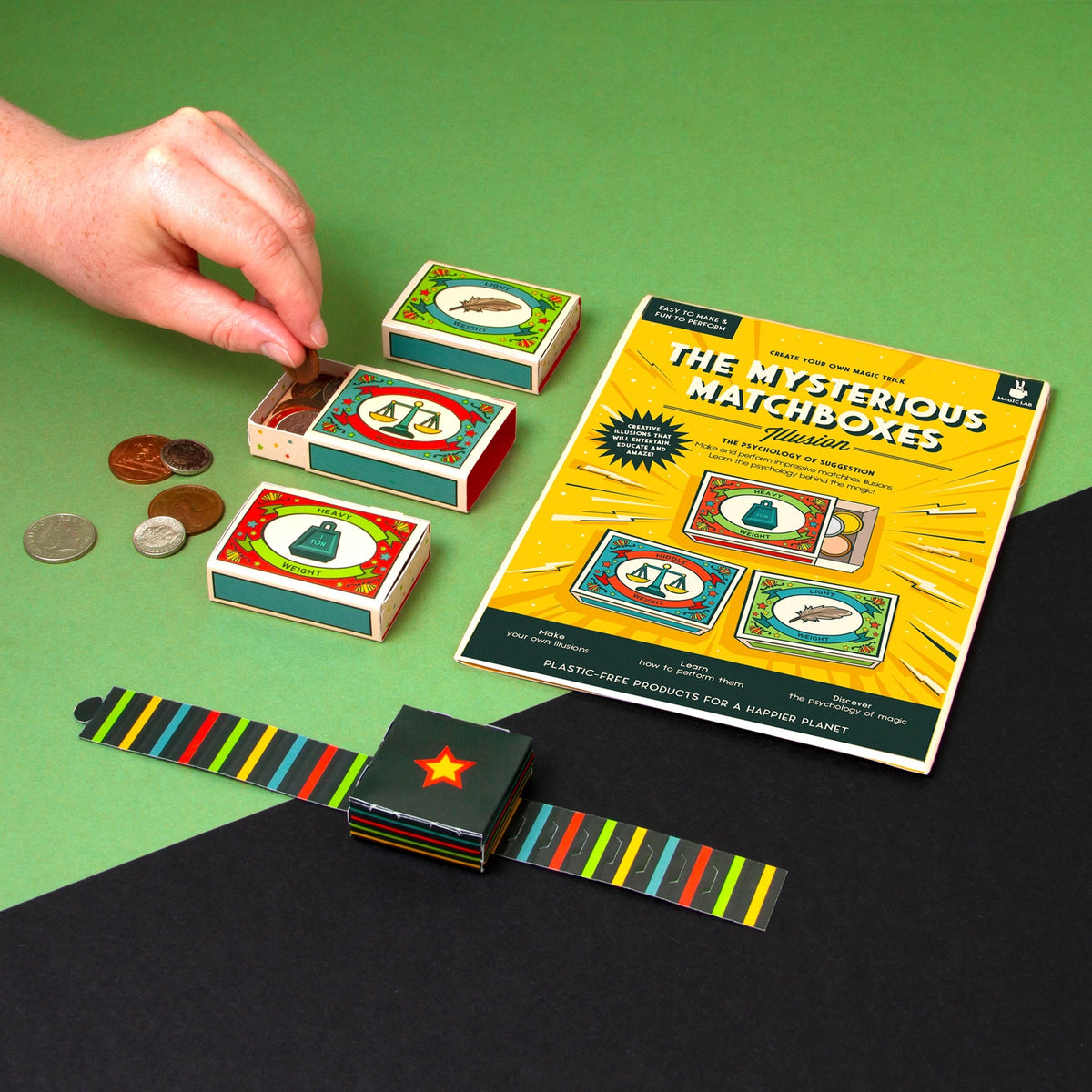 Matchbox game with matchboxes, coins, and a game board on a green and black background