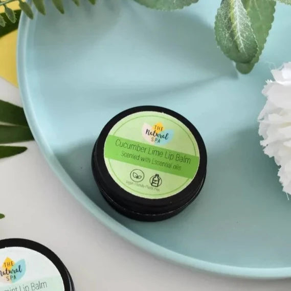 the natural spa cucumber lime lip balm packaged in a black aluminium tin with a green label. 
