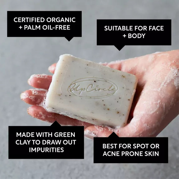 white personas hand holding UpCircle Cleansing Soap Bar with Fennel + Cardamom. Text around the image reads 'certfied organic + palm oil free'