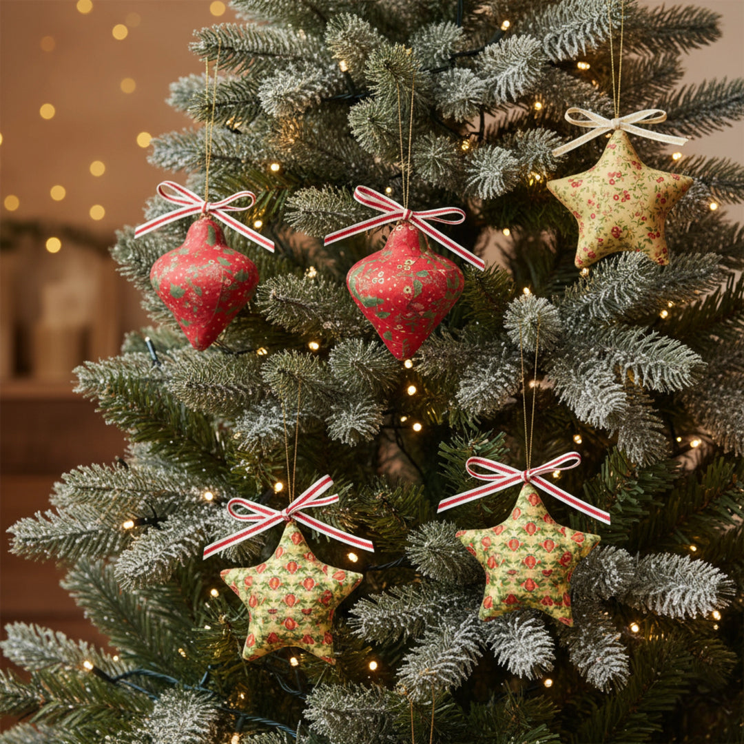 Decorated Christmas tree with red and patterned star upcycled christmas decorations and ornaments against a warm glow.