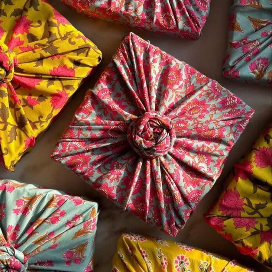 Colourful fabric gift wrap with floral patterns on a brown surface