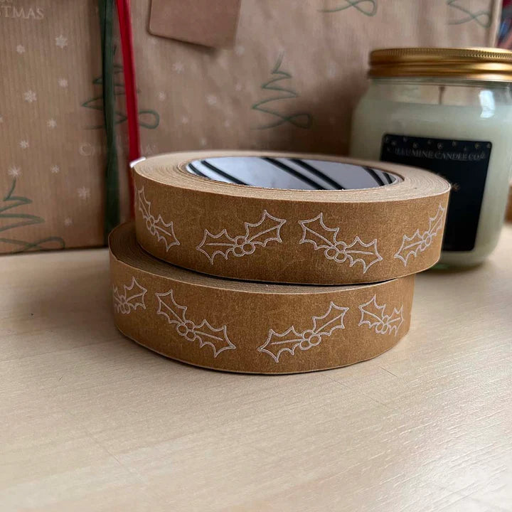 Two rolls of brown tape with white holly leaf pattern on a light surface.