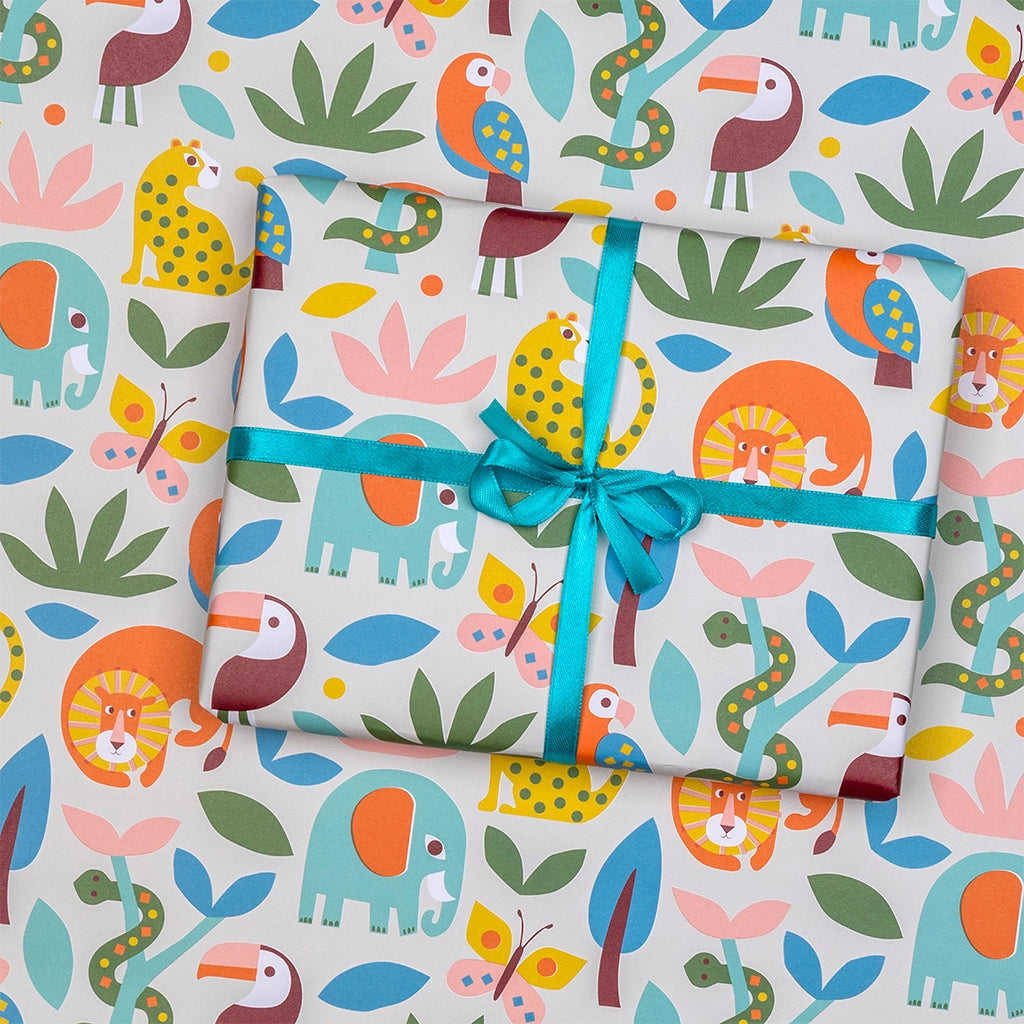 gift wrapped in colourful animal print wrapping paper with lions, elephants and leopards on a white background.