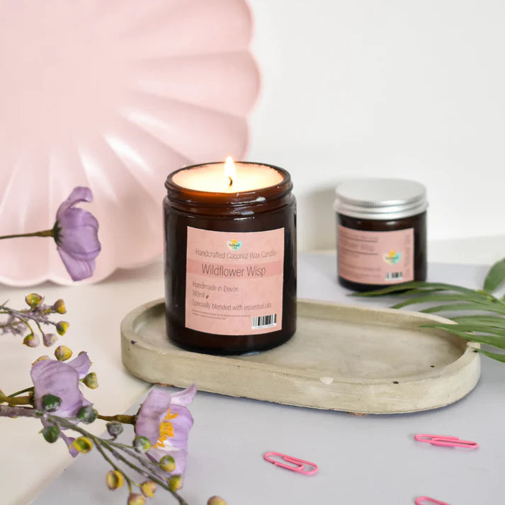 wildflower wisp coconut wax candle in an amber glass jar with a pick label