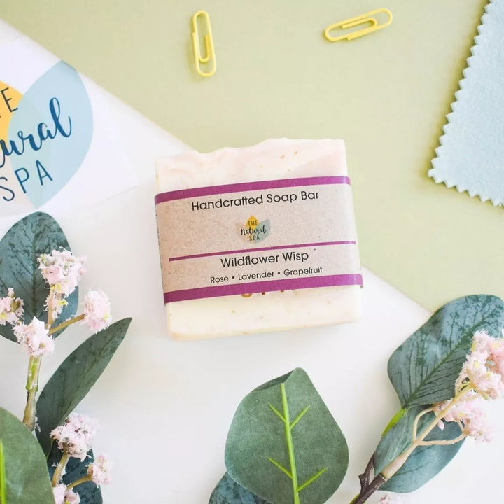wildflower wisp soap bar with 'handcrafted soap' label on a light background with green leaves. 