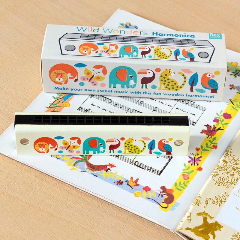 wooden harmonica with colourful painted animal design and gift box packaging on a table with sheet music