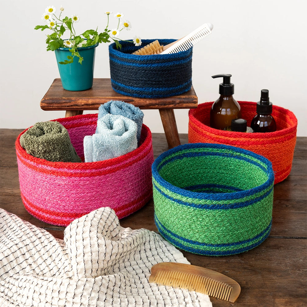 Colourful woven baskets on a wooden surface with various items inside.
