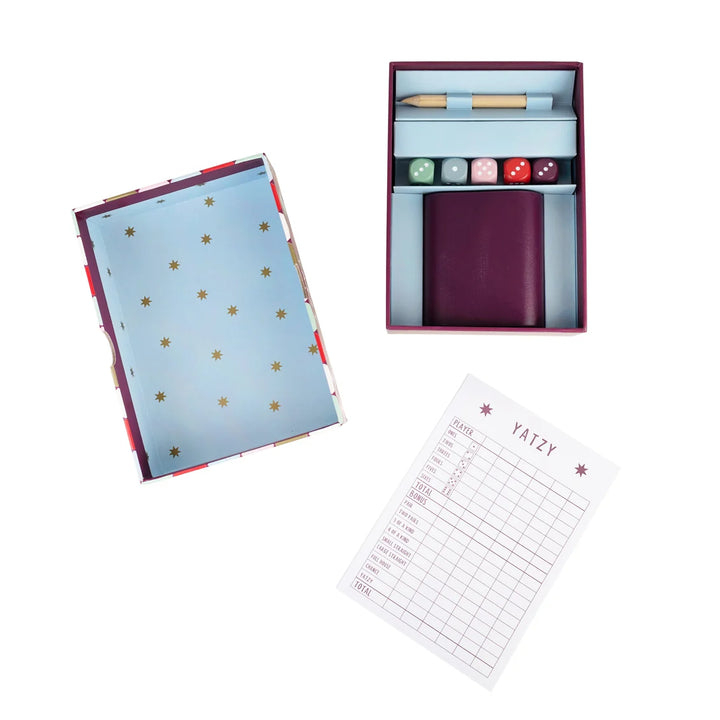 Yatzy game set with dice, dice cup, and score sheets on a white background