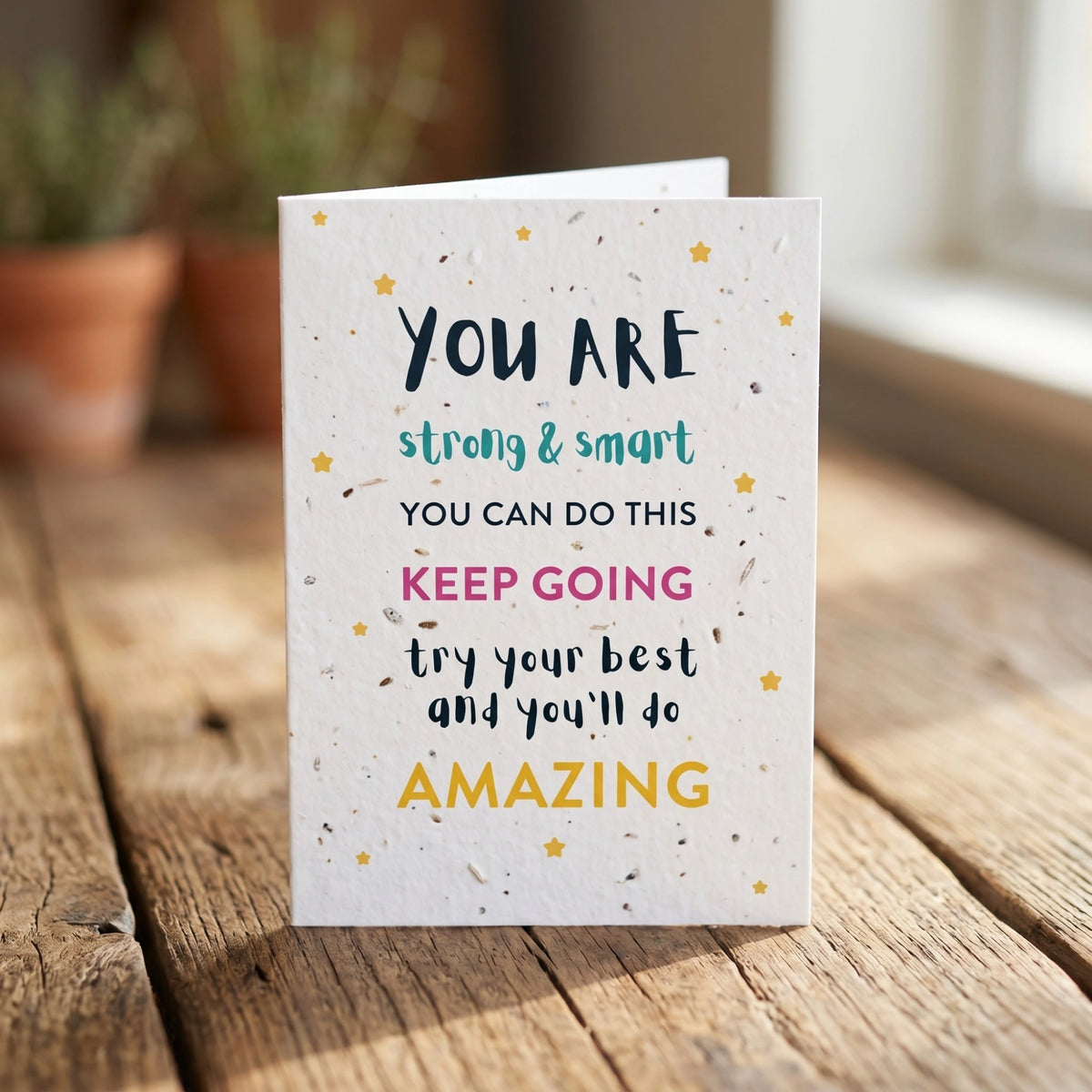 Motivational card with encouraging text on a wooden surface