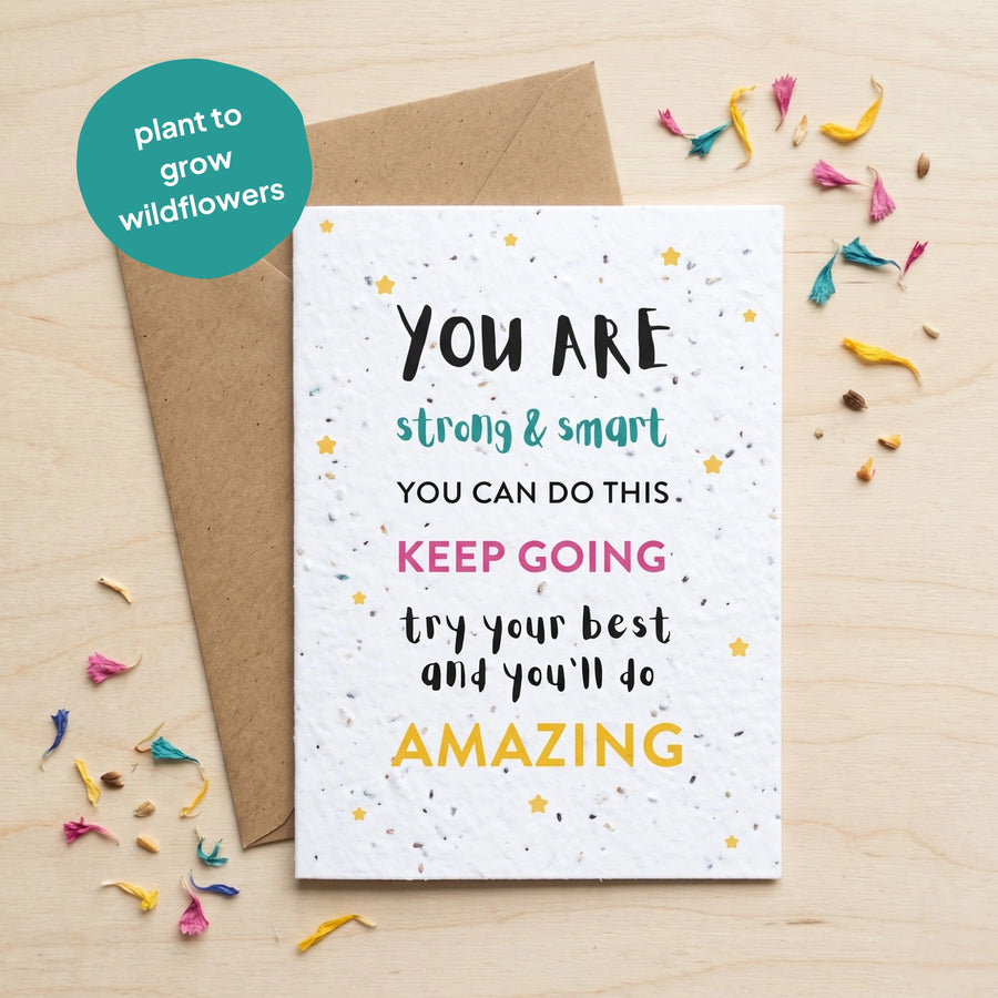 Motivational card with text on a wooden surface with wildflower seeds.