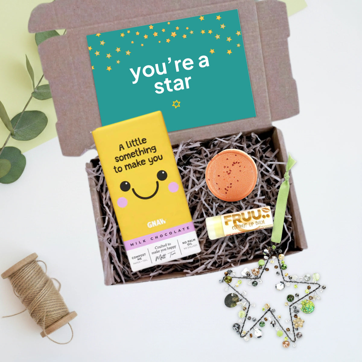 gift box with 'a little something to make you smile' chocolate bar, beaded hanging star decoration, shower steamer and a lip balm