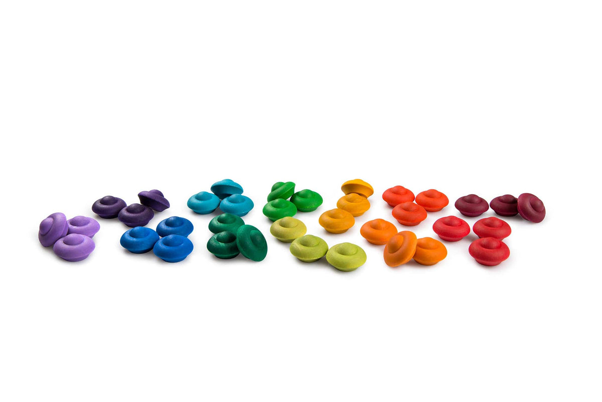 An array of Grapat wooden flowers in various rainbow colors arranged on a white background.