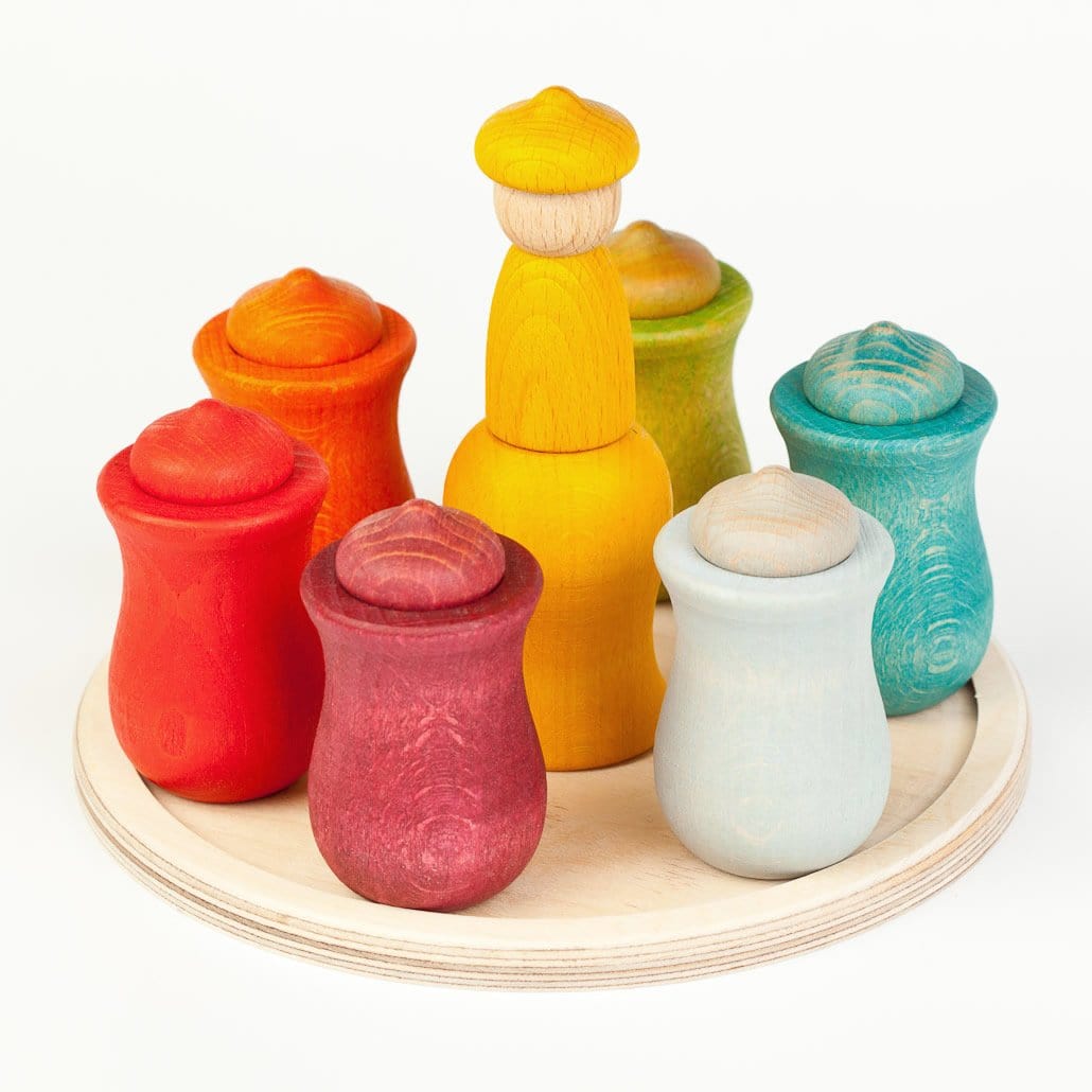 A set of Grapat 7 Moons Weekly Calendar toys including various colored acorn-shaped figures and cups, displayed on a wooden disk.