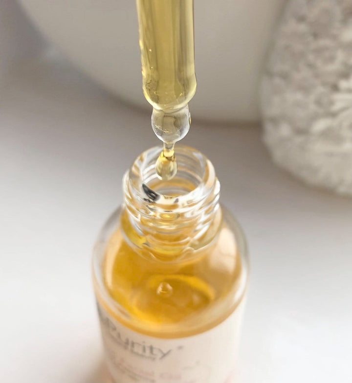 close up of organic facial oil in a glass jar with glass dropper